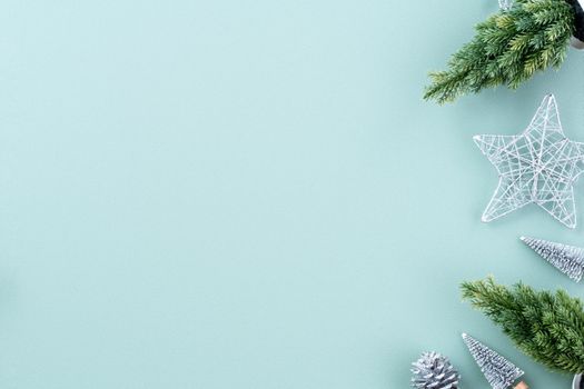 Top view of Christmas holiday decoration ornament composition with Christmas tree, gift star, gingerbread man flat lay with copy space isolated on green background.