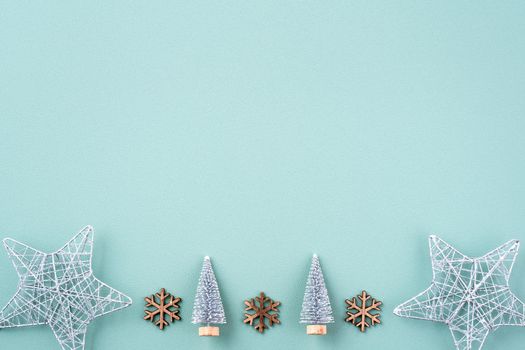 Top view of Christmas holiday decoration ornament composition with Christmas tree, gift star, gingerbread man flat lay with copy space isolated on green background.