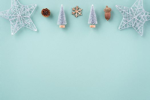 Top view of Christmas holiday decoration ornament composition with Christmas tree, gift star, gingerbread man flat lay with copy space isolated on green background.