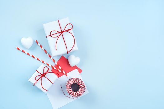 Valentine's Day greeting handmade gift design concept - Top view of wrapped gift box on bright blue background, flat lay overhead layout.