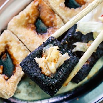 Deep fried stinky tofu, fermented bean curd with pickled cabbage vegetable, famous and delicious street food in Taiwan, lifestyle.