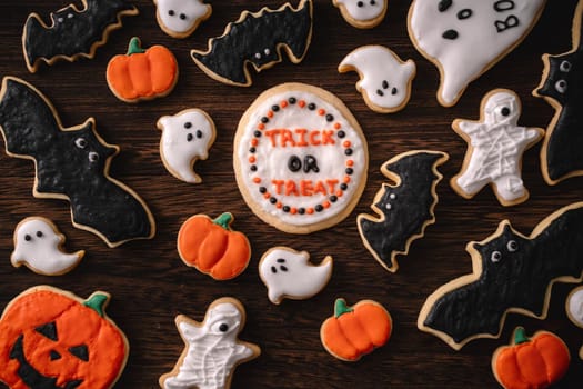 Top view of Halloween festive decorated icing gingerbread sugar cookies with copy space and flat lay layout.