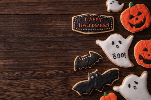 Top view of Halloween festive decorated icing gingerbread sugar cookies with copy space and flat lay layout.