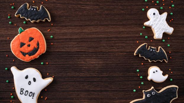 Top view of Halloween festive decorated icing gingerbread sugar cookies with copy space and flat lay layout.
