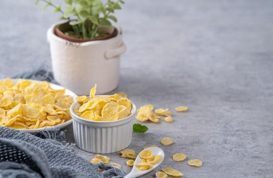 Corn flakes bowl sweeties with milk on gray cement background, close up, fresh and healthy breakfast design concept.