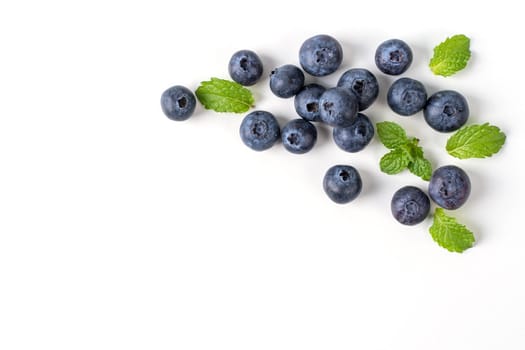 Blueberry fruit top view isolated on a white background, flat lay overhead layout with mint leaf, healthy design concept.