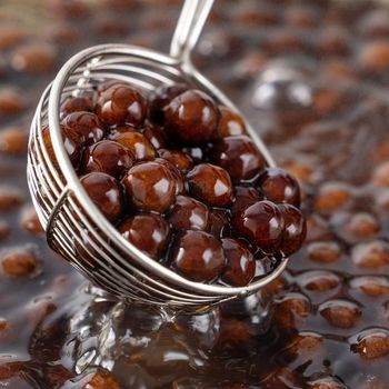 Cooking, boiling brown sugar flavor tapioca pearl balls, ingredient of bubble tea, preparing food and drink, close up, recipe cookbook steps design concept.