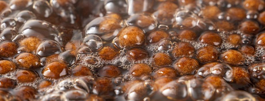 Cooking, boiling brown sugar flavor tapioca pearl balls, ingredient of bubble tea, preparing food and drink, close up, recipe cookbook steps design concept.