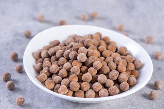 Dry raw brown tapioca pearls isolated on gray cement concrete background, close up, ingredient of making bubble boba tapioca milk tea.