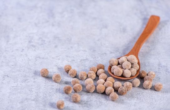 Dry raw brown tapioca pearls isolated on gray cement concrete background, close up, ingredient of making bubble boba tapioca milk tea.