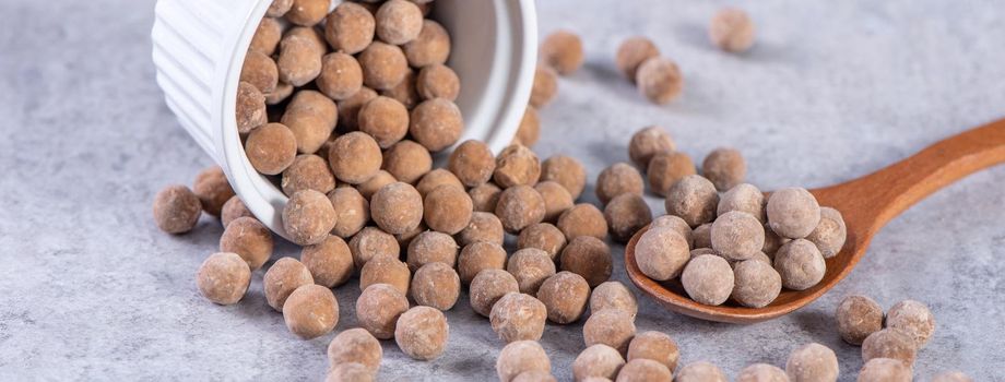 Dry raw brown tapioca pearls isolated on gray cement concrete background, close up, ingredient of making bubble boba tapioca milk tea.