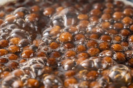 Cooking, boiling brown sugar flavor tapioca pearl balls, ingredient of bubble tea, preparing food and drink, close up, recipe cookbook steps design concept.