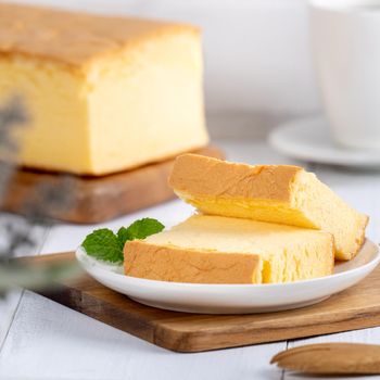 Plain classic Taiwanese traditional sponge cake (Taiwanese castella kasutera) on a wooden tray background table with ingredients, close up.