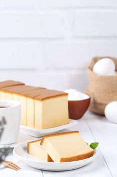 Castella (kasutera) - Beautiful delicious Japanese sliced sponge cake food on white plate over rustic white wooden table, close up, copy space design concept.