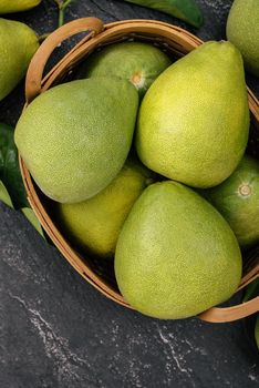 Fresh pomelo, pummelo, grapefruit, shaddock on black background, fruit for Mid-autumn festival, top view, flat lay.