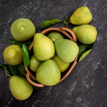 Fresh pomelo, pummelo, grapefruit, shaddock on black background, fruit for Mid-autumn festival, top view, flat lay.