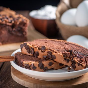 Chocolate flavor Taiwanese traditional sponge cake (Taiwanese castella kasutera) on a wooden tray background table with ingredients, close up.