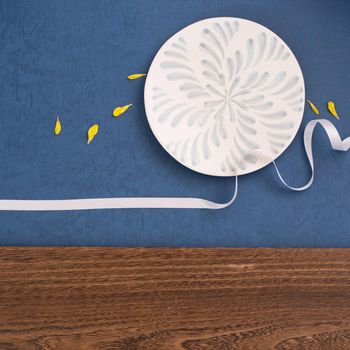 Conceptual Mid-Autumn Festival table background, symbol of moon, clouds and stars in the sky with plate, ribbon and yellow petal. Top view, flat lay.