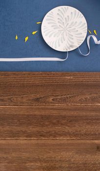 Conceptual Mid-Autumn Festival table background, symbol of moon, clouds and stars in the sky with plate, ribbon and yellow petal. Top view, flat lay.