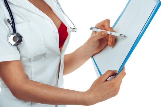 Close-up on hands of beautiful sexy female doctor with stethoscope writing diagnosis for patient, wearing in a sexy uniform. Posing isolated on white background. Unrecognizable person.