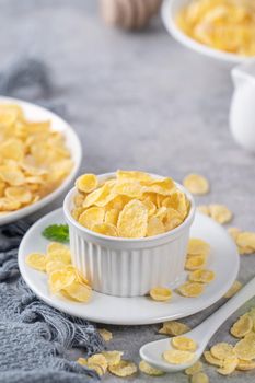 Corn flakes bowl sweeties with milk on gray cement background, close up, fresh and healthy breakbast design concept.
