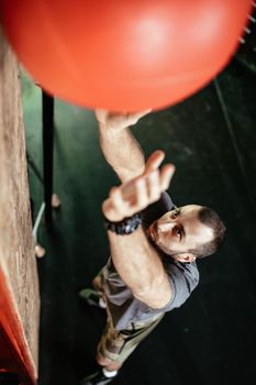Handsome young muscular man doing exercise with wall ball at the gym. Top view. Selective focus.