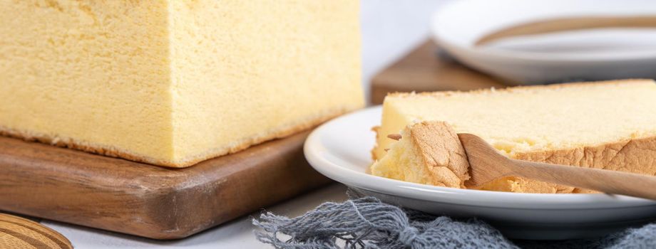 Plain classic Taiwanese traditional sponge cake (Taiwanese castella kasutera) on a wooden tray background table with ingredients, close up.