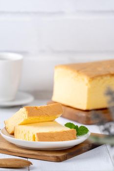 Plain classic Taiwanese traditional sponge cake (Taiwanese castella kasutera) on a wooden tray background table with ingredients, close up.