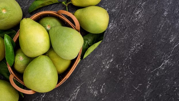Fresh pomelo, pummelo, grapefruit, shaddock on black background, fruit for Mid-autumn festival, top view, flat lay.