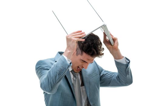 Portrait of an angry exhausted businessman throwing his laptop, isolated on white background. 