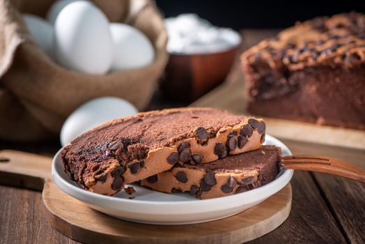 Chocolate flavor Taiwanese traditional sponge cake (Taiwanese castella kasutera) on a wooden tray background table with ingredients, close up.