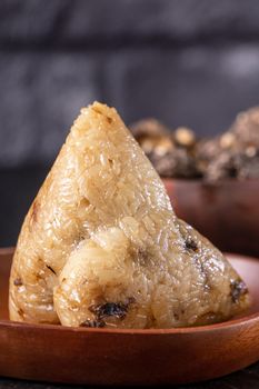 Rice dumpling, zongzi - Chinese rice dumpling zongzi on black brick background slate table, concept of Dragon Boat Festival traditional food, close up.