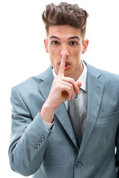 Young man asking to keep business plan in secret, making hush hand gesture with finger at his lips. Looking at camera. Isolated on white background.  