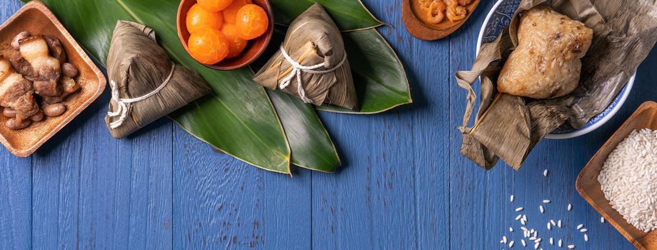 zongzi - Dragon Boat Festival concept Rice dumpling, traditional Chinese food on blue wooden background for Duanwu Festival, top view, flat lay design concept.