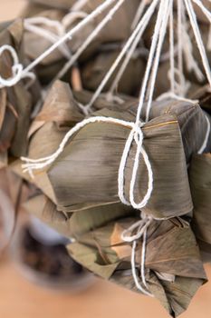 Rice dumpling - Chinese zongzi food in a steamer on wooden table with red brick wall, window background at home for Dragon Boat Festival concept, close up.