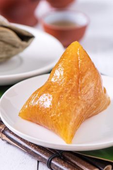 Zongzi - Alkaline rice dumpling - Traditional sweet Chinese crystal food on a plate to eat for Dragon Boat Duanwu Festival celebration concept, close up.