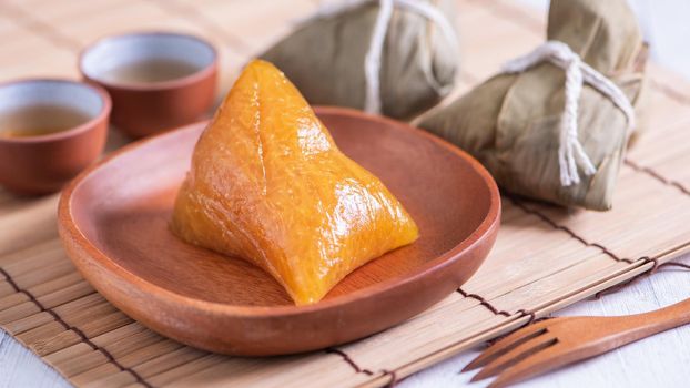 Zongzi - Alkaline rice dumpling - Traditional sweet Chinese crystal food on a plate to eat for Dragon Boat Duanwu Festival celebration concept, close up.