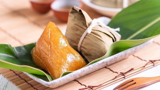 Zongzi - Alkaline rice dumpling - Traditional sweet Chinese crystal food on a plate to eat for Dragon Boat Duanwu Festival celebration concept, close up.