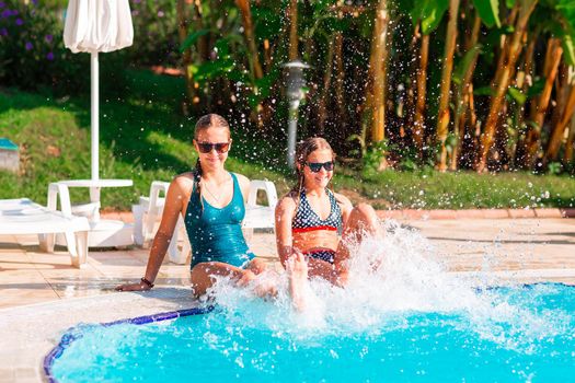 Happy beautiful girls having fun at the pool at the resort