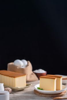 Castella - Delicious Japanese sliced sponge cake food on white plate over rustic wooden table, close up, healthy eating, copy space design.