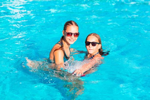 Happy beautiful girls having fun at the pool at the resort