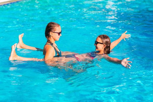 Happy beautiful girls having fun at the pool at the resort