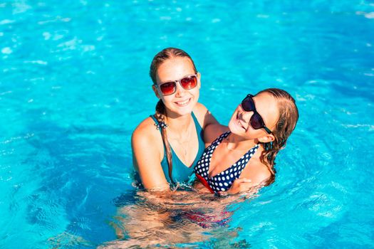 Happy beautiful girls having fun at the pool at the resort