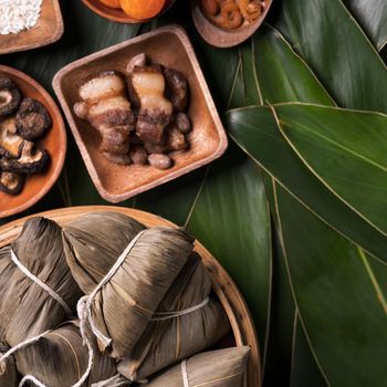 Rice dumpling, zongzi - Traditional Chinese food on green leaf background of Dragon Boat Festival, Duanwu Festival, top view, flat lay design concept.