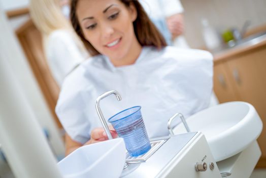 Beautiful young woman in visit at the dentist office preparing for checking up her teeths.