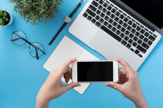Social network connecting office table concept with fashion accessories, minimal interior with a woman holding smartphone, top view, flat lay, mockup, copy space