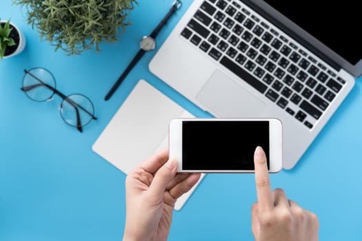 Social network connecting office table concept with fashion accessories, minimal interior with a woman holding smartphone, top view, flat lay, mockup, copy space