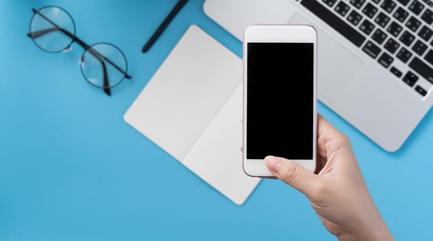 Social network connecting office table concept with fashion accessories, minimal interior with a woman holding smartphone, top view, flat lay, mockup, copy space