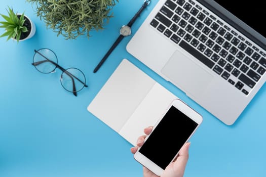 Social network connecting office table concept with fashion accessories, minimal interior with a woman holding smartphone, top view, flat lay, mockup, copy space