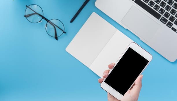 Social network connecting office table concept with fashion accessories, minimal interior with a woman holding smartphone, top view, flat lay, mockup, copy space